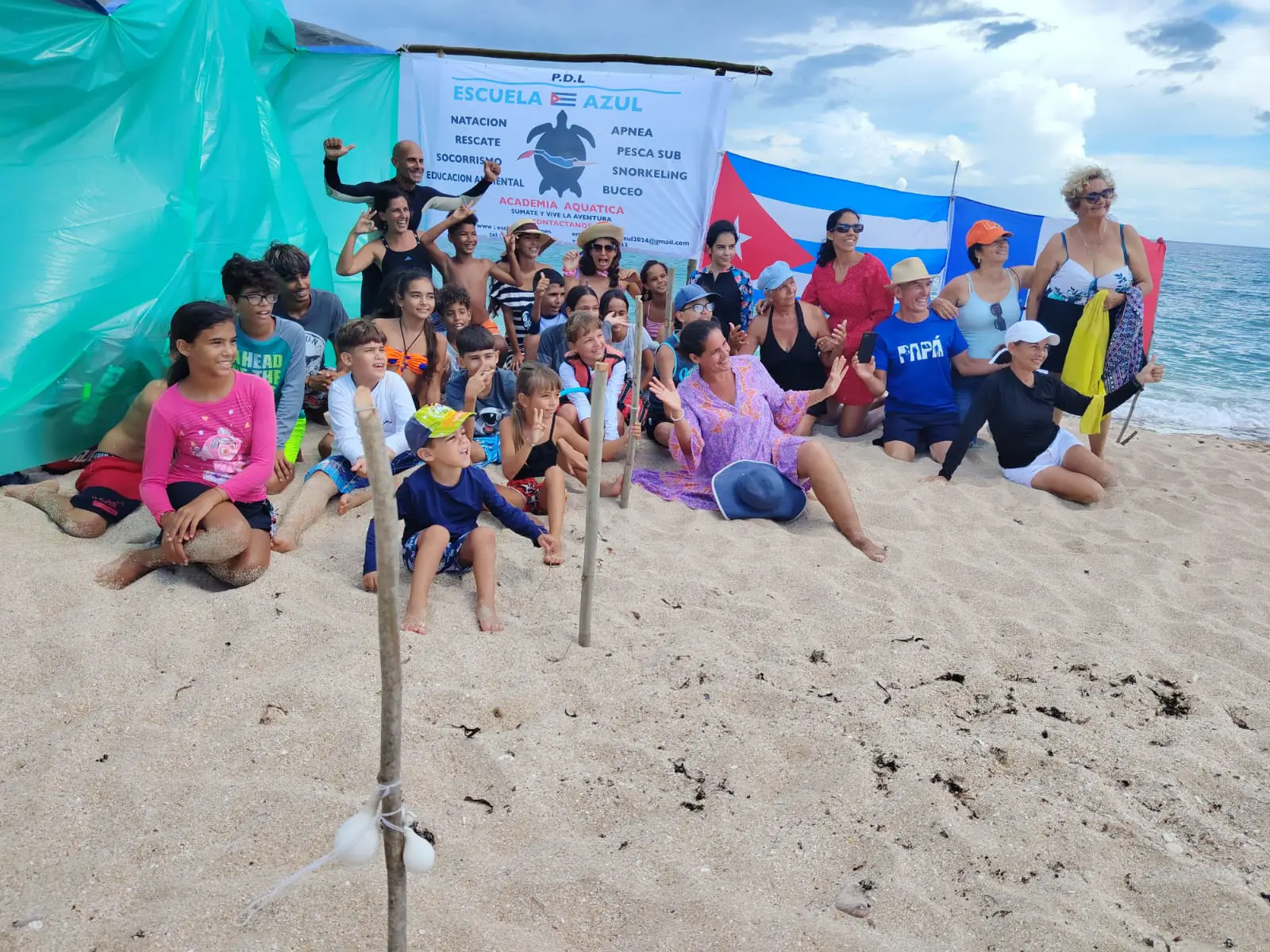 Foto de grupo al final del evento en la playa.